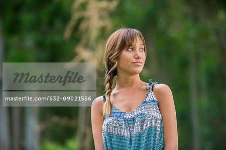 Young woman looking away in though and smiling outdoors