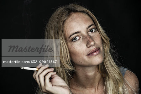 Young woman holding cigarette, portrait