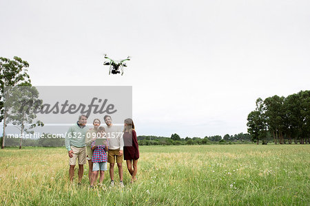 Family playing with drone in field