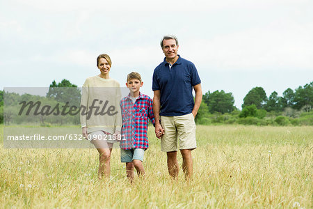 Family with one child on walk together in open field