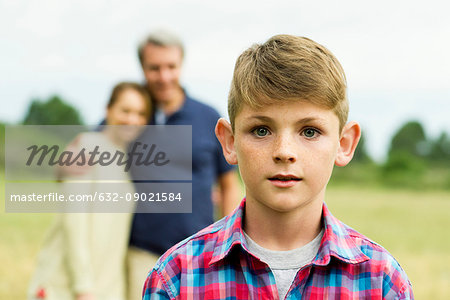 Boy with parents in background, portrait