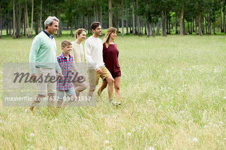Family taking walk together through field