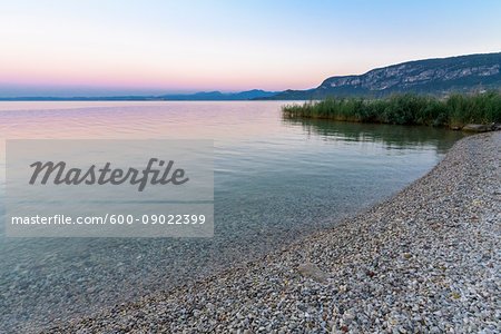Close-up of shoreline at Lake Garda (Lago di Garda) at dawn in Garda in Veneto, Italy