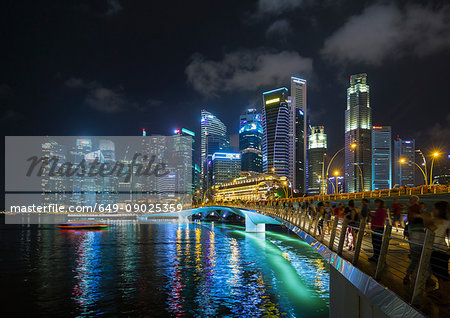 Crowds of tourists on waterfront bridge at Marina Bay at night, Singapore, South East Asia