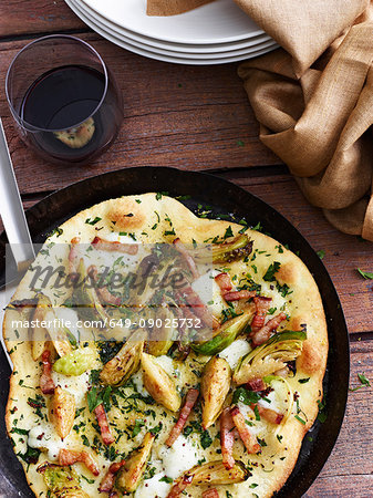 Mustard, brussel sprout and pancetta pizza in pizza dish, elevated view