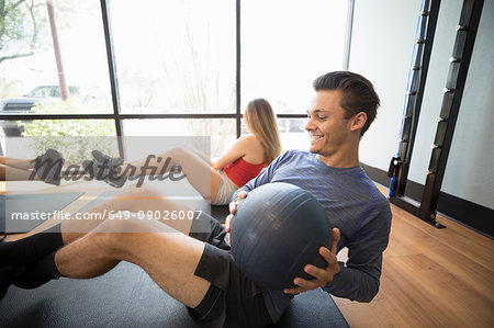 Friends training with medicine ball in gym