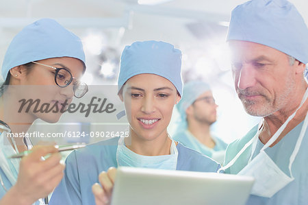 Surgeons using digital tablet in operating room