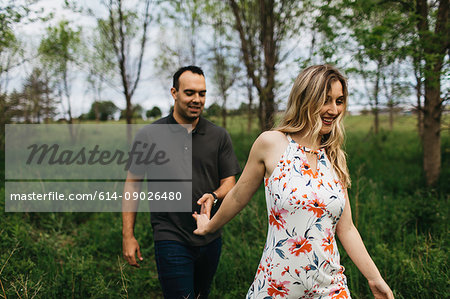 Romantic couple holding hands in field
