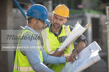 Project manager and construction worker looking at plans