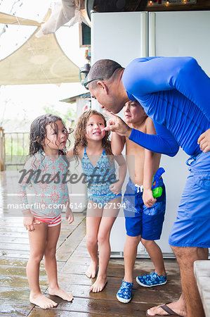 Man playfully scolding children