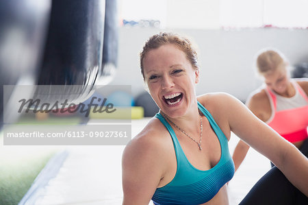 Portrait laughing female boxer stretching in gym