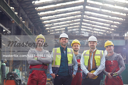 Portrait confident engineers and workers in factory