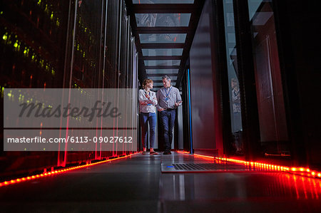 IT technicians talking and walking in dark server room