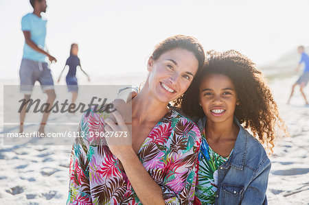 Portrait smiling, affectionate mother and daughter on sunny summer beach