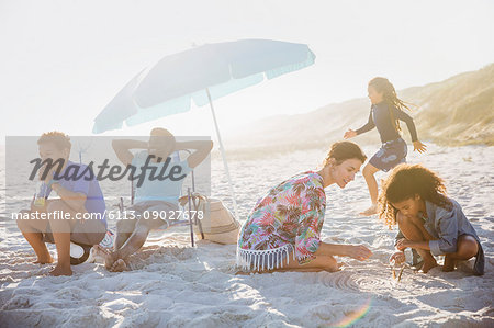 Multi-ethnic family relaxing and playing on sunny summer beach
