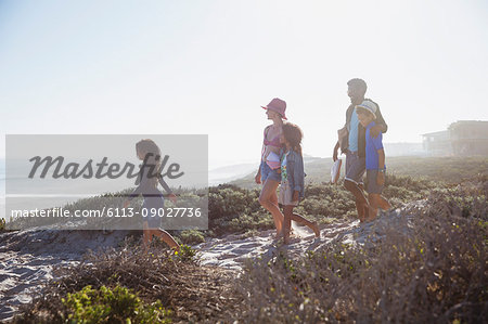 Family walking on sunny summer beach path