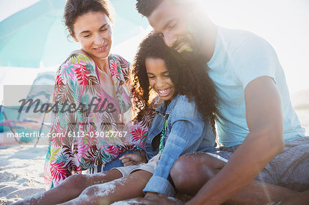 Multi-ethnic family relaxing on sunny summer beach