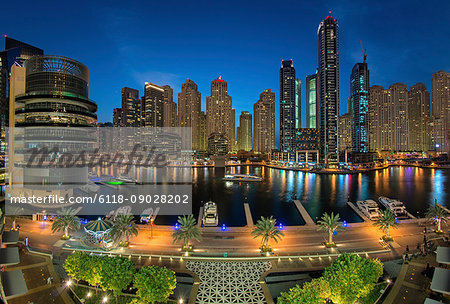 Cityscape of Dubai, United Arab Emirates at dusk, with skyscrapers and the marina in the foreground.