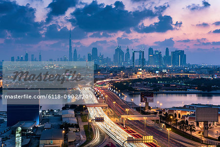 Cityscape of the Dubai, United Arab Emirates at dusk, with highway across the marina and skyscrapers in the distance.
