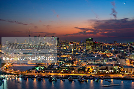 Cityscape of Dubai, United Arab Emirates at dusk, with illuminated skyscrapers in the distance.