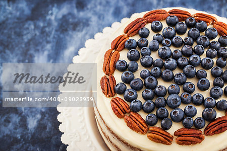 Delicious homemade naked carrot cake decorated with fresh blueberry and pecan