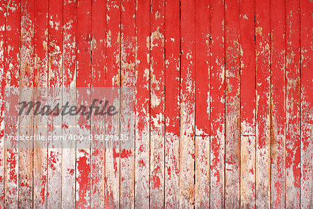 Texture of ancient wood with cracked paint of red color