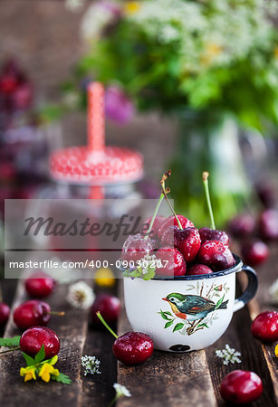 Fresh wet cherry in enamel metal mug, summer concept