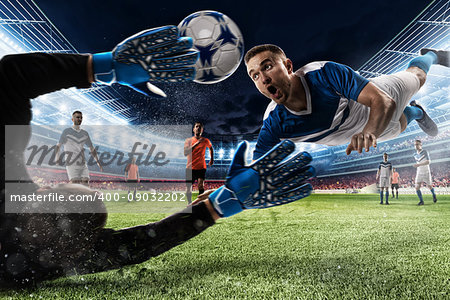 Goalkeeper catches the ball in the stadium during a football game