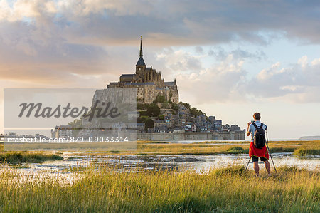 Man taking pictures at sunset. Mont-Saint-Michel, Normandy, France.