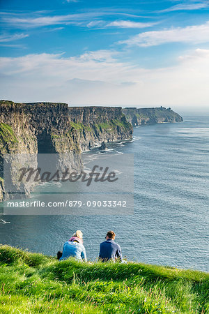 Couple admiring the landscape. Cliffs of Moher, Liscannor, Co. Clare, Munster province, Ireland.