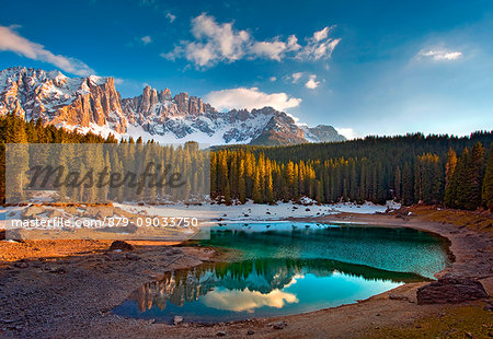 Dolomites. The Carezza lake, with fir forests and the Latemar ridge in the background, at sunset Dolomites. The Carezza lake, with fir forests and the Latemar ridge in the background, at sunset