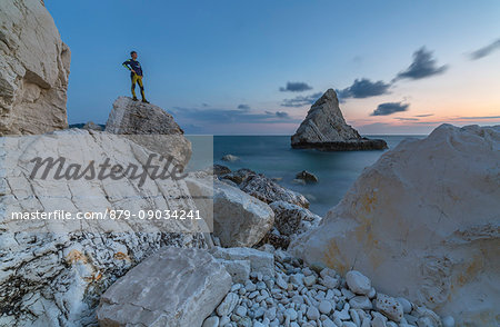 Dusk lights on cliffs framed by clear sea La Vela Beach Portonovo province of Ancona Conero Riviera Marche Italy Europe