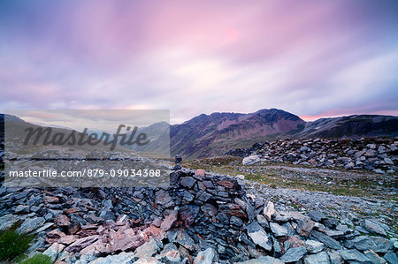 Pink clouds at sunrise frame the war trenches on rocky peaks Braulio Valley Stelvio Pass Valtellina Lombardy Italy Europe