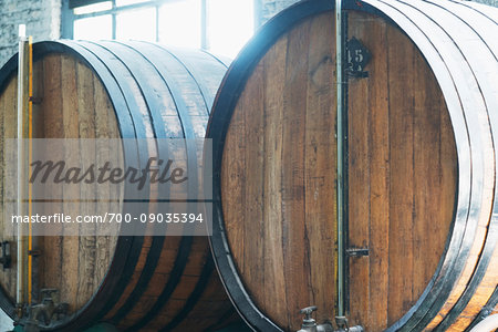 Close-up of whisky casks in front of a window in a traditional French distillery in northern France