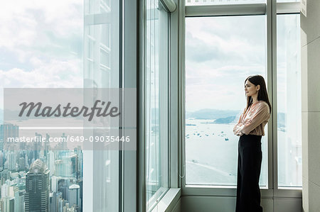 Business woman looking out of window at cityscape
