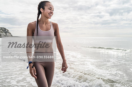 Young woman walking in sea, smiling