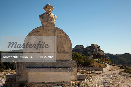 Monument of Charloun Rieu and view of distant town and castle, Les Baux-de-Provence, Provence-Alpes-Côte d'Azur, France