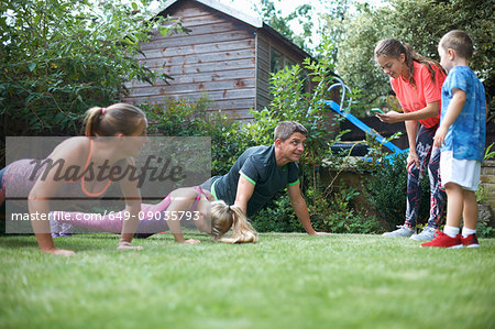 Family exercising in garden, doing push-ups