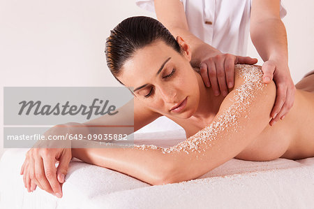 Woman in spa environment, having salt crystal massage