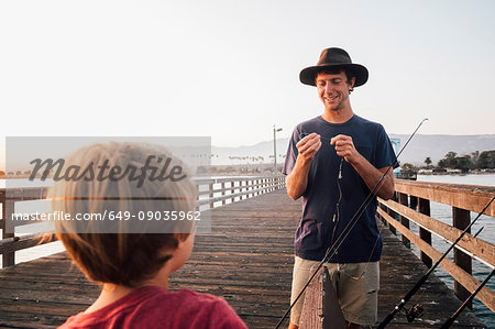 Father and son on pier preparing fishing rods, Goleta, California, United States, North America