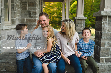 Family of five sitting on front porch