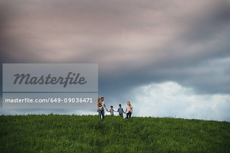 Family of five enjoying outdoors on green grassy field