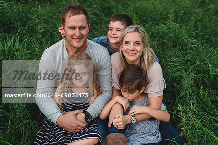 Family of five enjoying outdoors on green grassy field