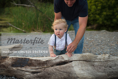 Man with toddler son toddling on beach, Lake Ontario, Canada