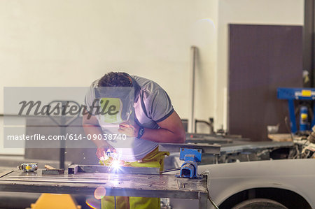 Man welding in bodywork repair shop