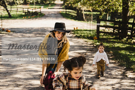 Mother and children on farmland, riding bicycle, Oshawa, Canada, North America