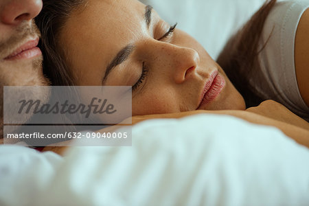 Young woman resting in bed with partner