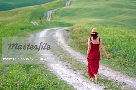 Europe,Italy, Tuscany Siena district, Val d'Orcia. Girl runs