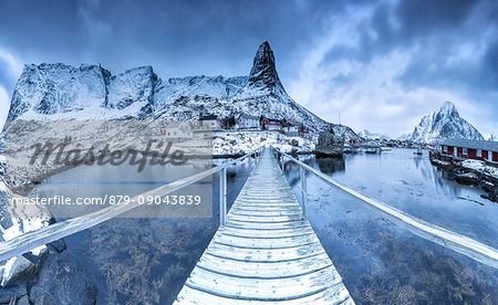 A bridge over the cold sea connects a typical fishing village. Lofoten Islands Northern Norway Europe