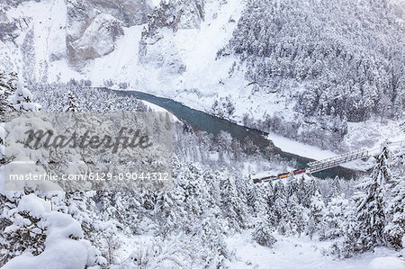 The Red Train passes in the gorge despite heavy snow. Rhein Gorge(Ruinaulta), Flims, Imboden, Graubunden, Switzerland, Europe